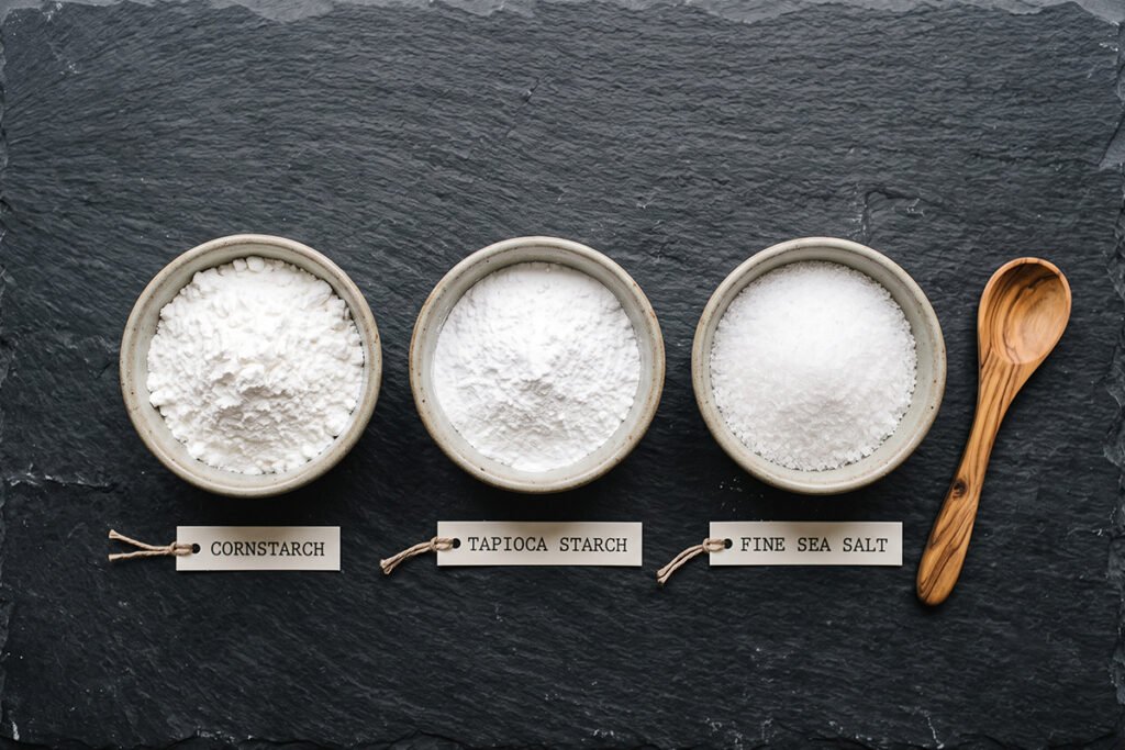 A comparison layout showing natural starch powders alongside fine sea salt.