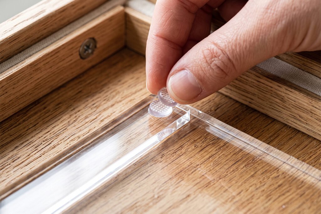 Applying small rubber anti-slip pads to the bottom corner of an acrylic drawer