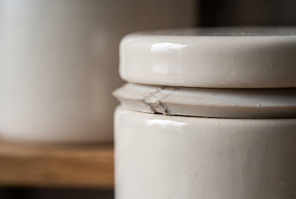 Close-up of a rubber gasket tightly pressed against the rim of a high-end ceramic storage jar