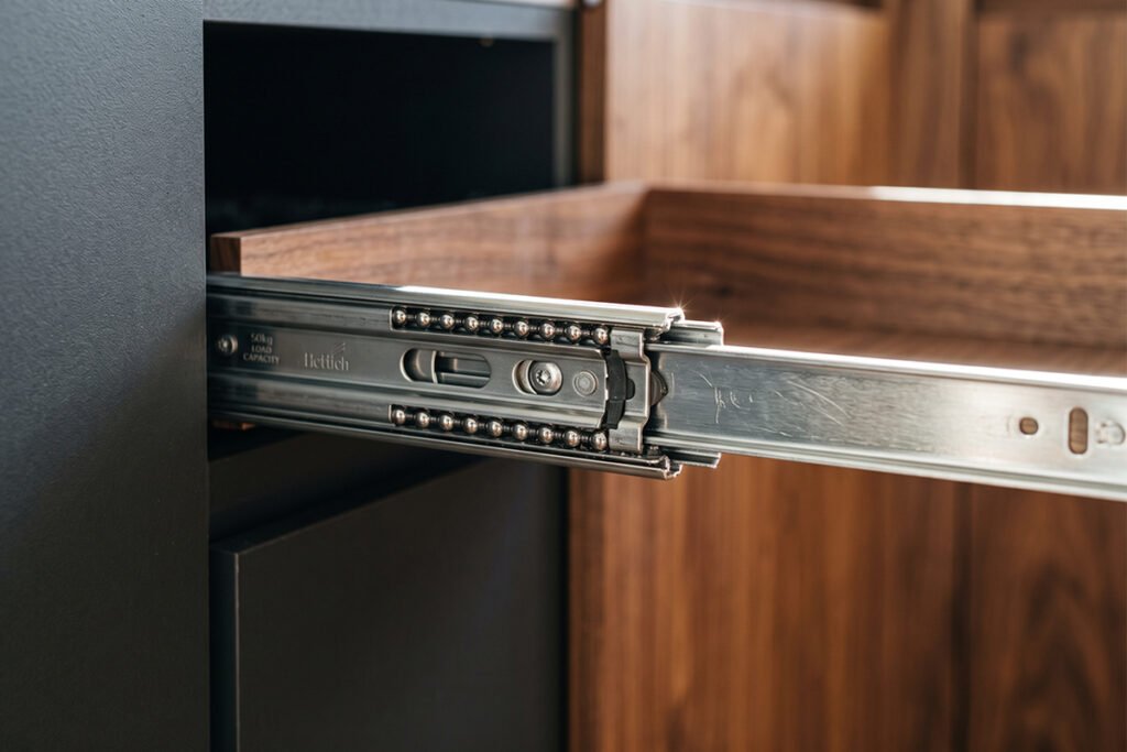 Close-up of heavy-duty full-extension drawer slides extended fully out of a kitchen