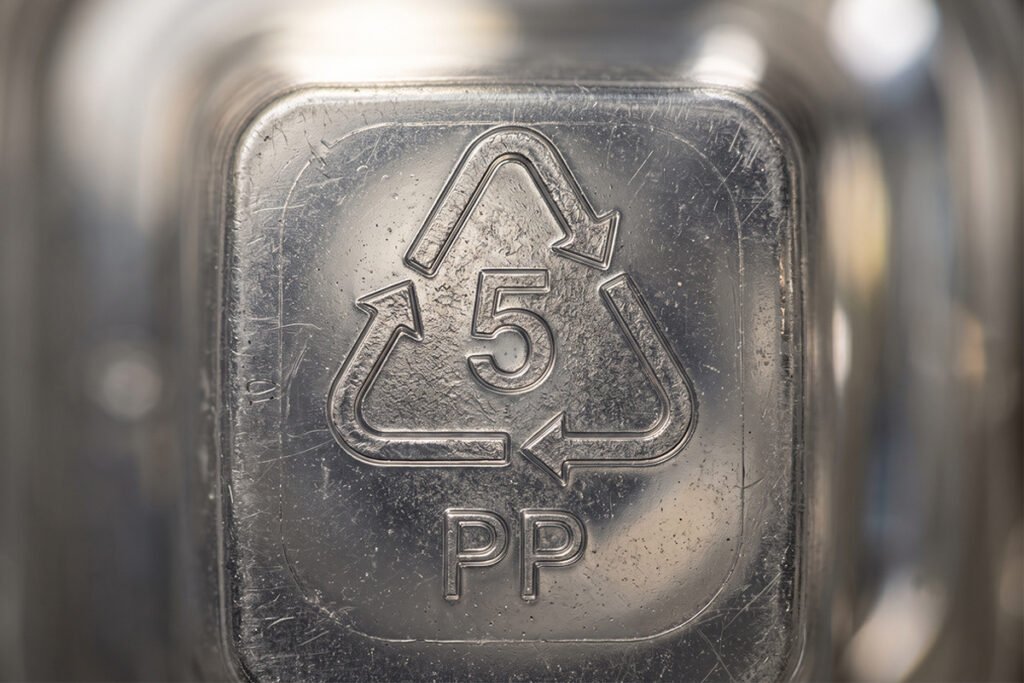 Close up shot of the recycling number 5 symbol stamped on a clear plastic container