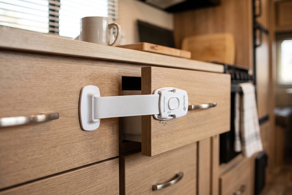 Hand operating a high-friction RV cabinet turn-latch on an upper wood cabinet