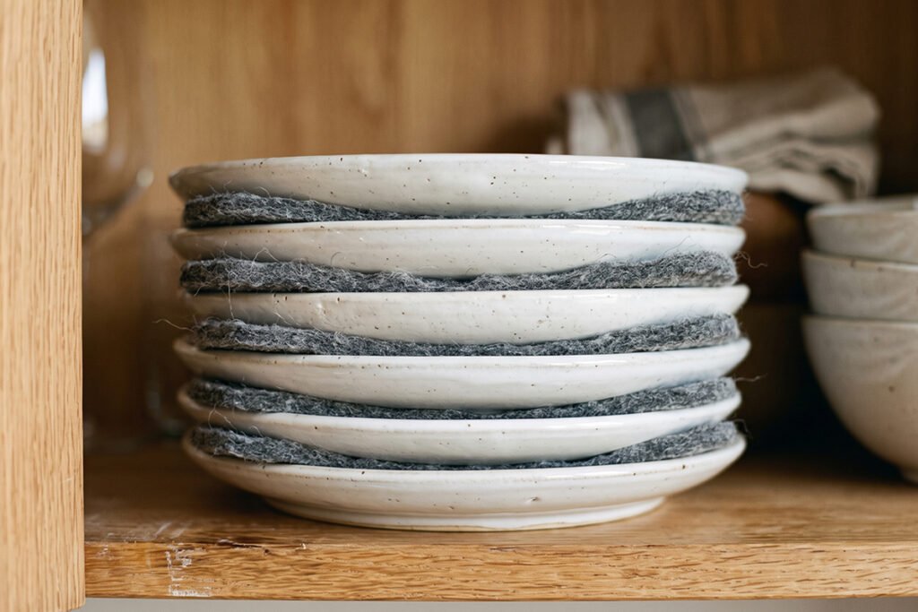 Lightweight melamine bowls and plates nested compactly in a shallow RV drawer