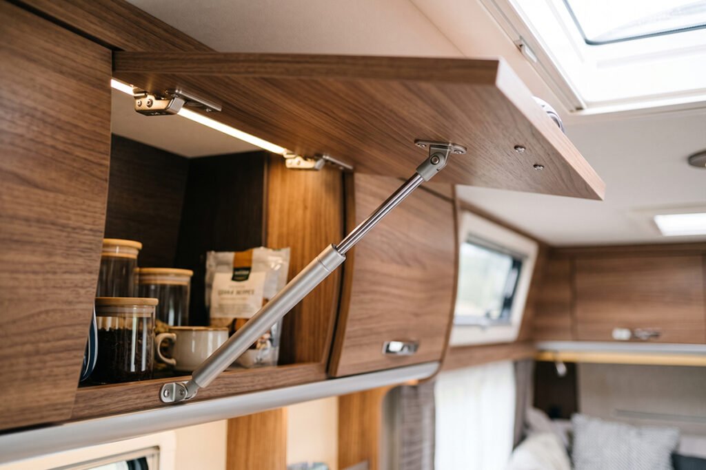 Person placing reusable museum putty under a coffee maker on an RV countertop