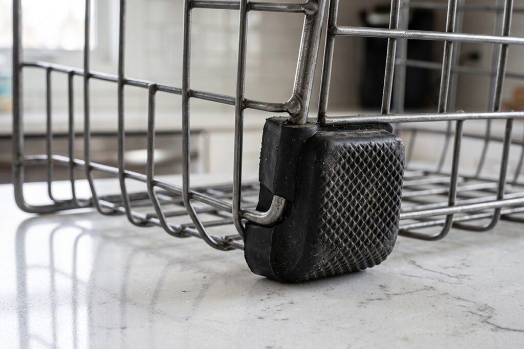 Rubber non-slip feet detailed on the bottom of a metal storage basket.
